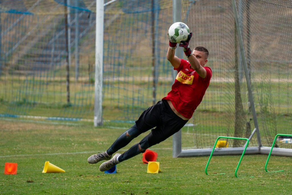 Torwart fängt den Ball sicher im Flug beim Torwarttraining